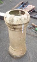 An old brick clay chimney pot with louvered top