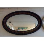 A 1920's wood grained framed oval wall mirror with egg-and-dart border