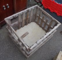 A rustic slatted wood log crate