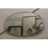 Two vintage frameless wall mirrors, both with bevelled oval plates