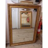 A modern gilt framed bevelled oblong wall mirror with decorative border