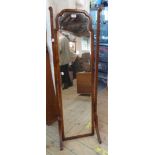 A 1930's walnut veneered cheval mirror with shaped bevelled oblong plate, set on splayed standard