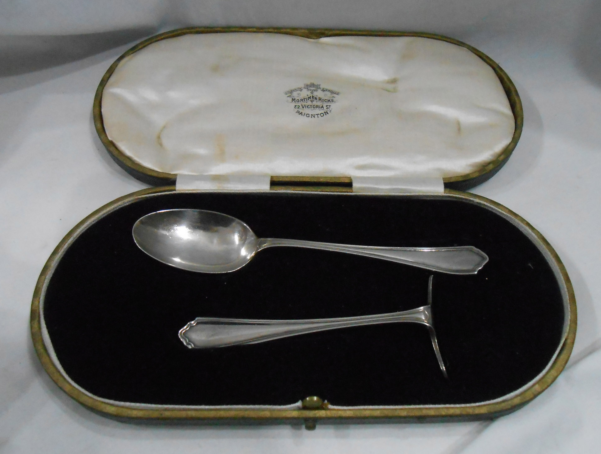 A cased Sheffield silver spoon and pusher in Mortimer Ricks, Victoria Street, Paignton retailers