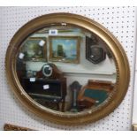A gilt framed bevelled oval wall mirror - damage to frame