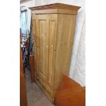 A 94cm Victorian waxed pine wardrobe with hanging space enclosed by a panelled door over a single