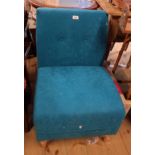 A retro style salon chair with button back teal suede upholstery and simple tapered legs