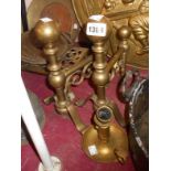 A pair of Victorian brass fire dogs - sold with a brass chamberstick