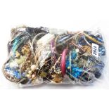 A bag containing a quantity of assorted costume jewellery