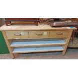 A 1.76m modern mixed wood shop counter with three frieze drawers and two open shelves under, set
