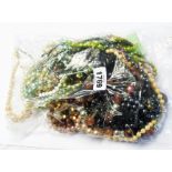 A bag containing a quantity of costume jewellery, mainly necklaces