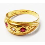 An 18ct. gold gypsy set ring with two small rubies and tiny diamond - size Q 1/2