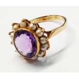 A 375 (9ct.) gold ring, set with central oval amethyst within a seed pearl border - size N - boxed