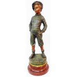 A large spelter figure depicting a young boy whistling with hands in pockets with painted and bronze