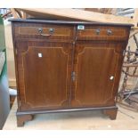 A small reproduction mahogany side cabinet with two frieze drawers and a pair of cupboard doors