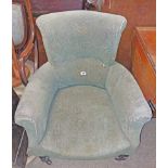 An Edwardian drawing room armchair with remains of original upholstery, set on turned front legs and