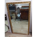 A 57cm modern gilt framed oblong wall mirror with pierced scroll border