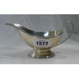 A silver gravy boat with cast reeded rim and cast oval foot - London 1932