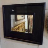 A wide stained wood framed bevelled oblong wall mirror - some veneer lifting