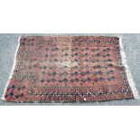 A Middle Eastern handmade wool prayer mat with remains of geometric design on russet ground - 1.4m X