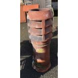 An old terracotta chimney pot with louvered top