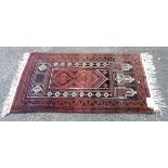 A vintage Afghan handmade wool prayer mat with central motifs within a decorative triple border -