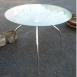 A modern glass topped table with chrome plated legs