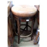 A modern bar stool by Theodore Alexander with swivel action and brown leather upholstered top, set