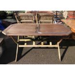 A teak garden table of slatted form - sold with five matching chairs
