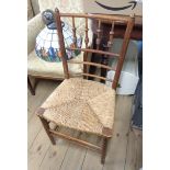 A pair of old stained beech framed spindle back chairs with woven rush seat panels