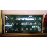 Two wooden display cases containing a large quantity of military cap badges including The Suffolk