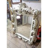 A reproduction Rococo style ornate white painted framed bevelled oblong wall mirror