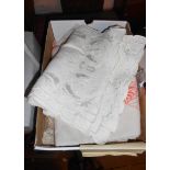 A box containing a small quantity of table linen including tray cloths, tablecloths, napkins, etc.