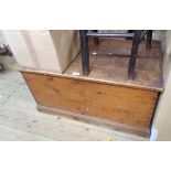An 86cm old stained pine lift-top trunk with part internal candle box and flanking iron drop handles