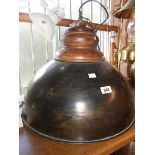 A large industrial style hanging ceiling lamp with metal dome and wooden fitting