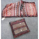 A North African tribal camel bag with lines of geometric decoration - sold with a camel bag cushion