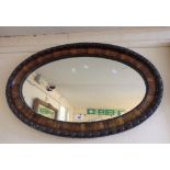 A 1920's wood grained framed oval wall mirror with egg-and-dart border
