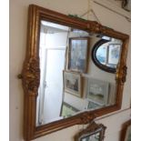 An antique style ornate gilt framed bevelled oblong wall mirror with wide border