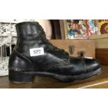 An old army issue black leather boot with wooden infill to repurpose as a doorstop