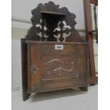A small old oak corner shelf with pierced Gothic cross decoration to top, over a single cupboard