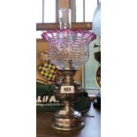 An old French small silver plated oil lamp with glass chimney and moulded cranberry glass shade