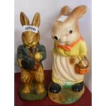 An old cellulose finish ceramic money box depicting a mother rabbit holding a basket containing