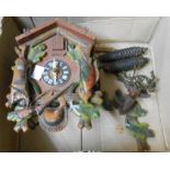 A vintage tourist ware cuckoo wall clock with painted detail, acorn pattern weights and pendulum