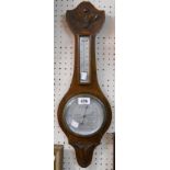 A 20th Century polished and carved oak framed 'Weathertide' banjo barometer/thermometer with aneroid