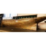 A large wood and fibreglass model boat hull