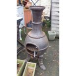 A 1.1m tall cast iron chimenea, set on decorative triple feet