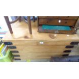 An 81cm old waxed pine lift-top trunk with metal bound corners and flanking iron drop handles