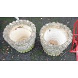 A pair of circular concrete garden planters with floral sides and lobed rims