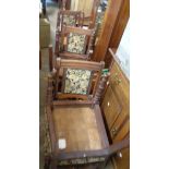 A set of six Edwardian oak framed panel back dining chairs with studded upholstery, set on turned