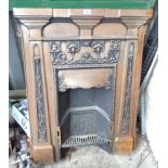 An old cast iron fire surround with flower motif to top, climbing floral decoration to pillars and