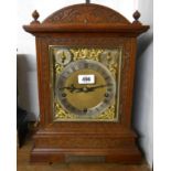 A late 19th Century ornate carved oak cased table clock with brass and silvered dial marked for